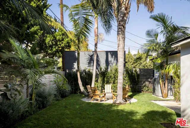 a view of a house with a yard and palm trees