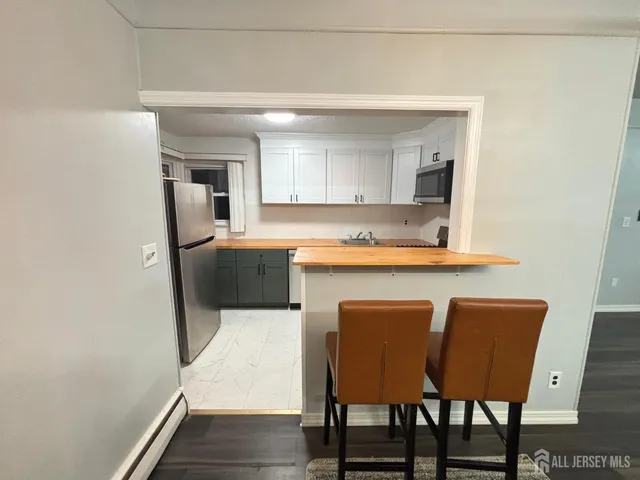 a kitchen with stainless steel appliances a table and chairs in it