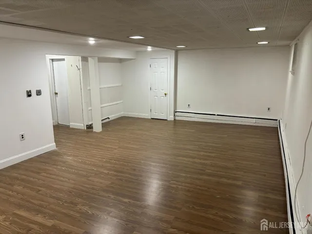 a view of an empty room with wooden floor