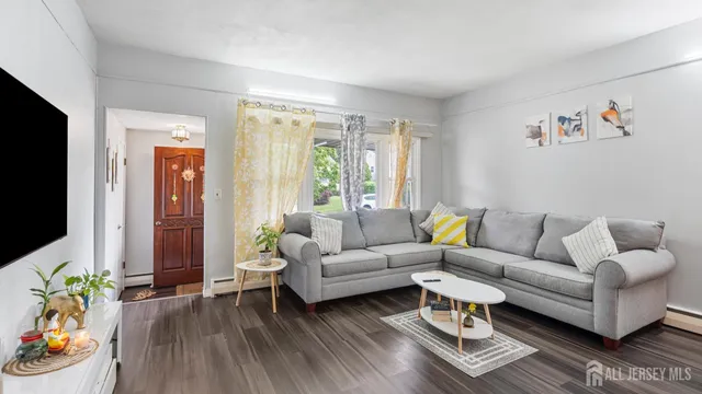 a living room with furniture a flat screen tv and a window