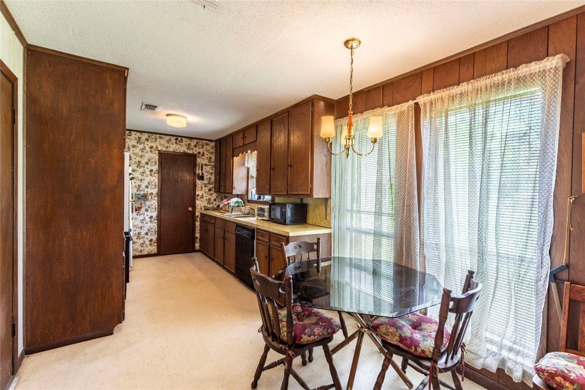 125 Forrest Lane Brenham, TX 77833 - Photo 11 of 13 a kitchen with stainless steel appliances a table chairs and chandelier