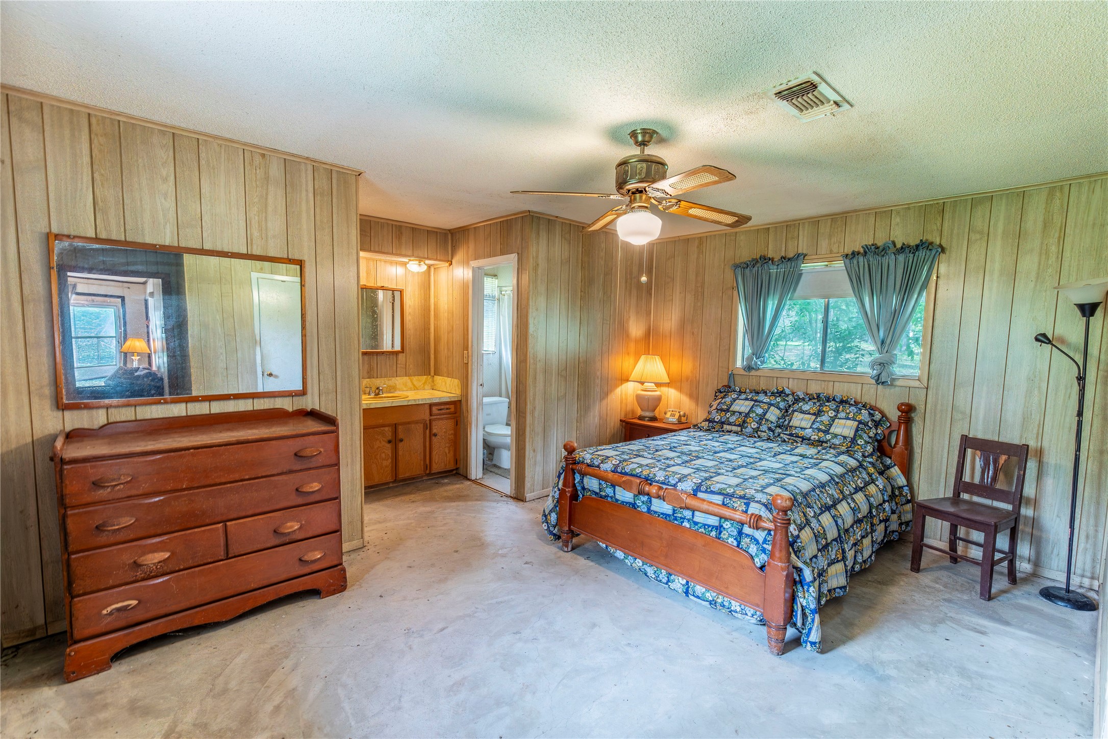 125 Forrest Lane Brenham, TX 77833 - Photo 8 of 13 a bedroom with a bed a chandelier and dresser