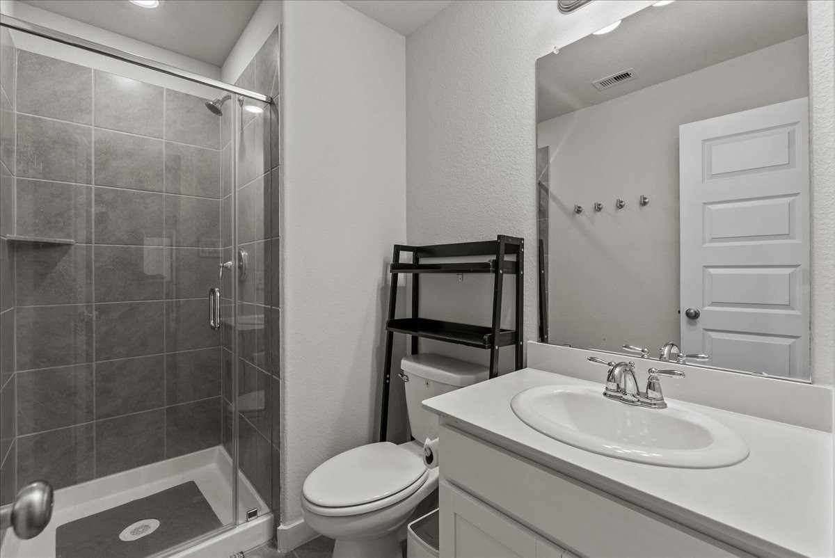10831 Bodie Hls Drive Rosharon, TX 77583 - Photo 26 of 46 A full bathroom upstairs is accessible to all secondary bedrooms and includes a shower and storage cabinetry.