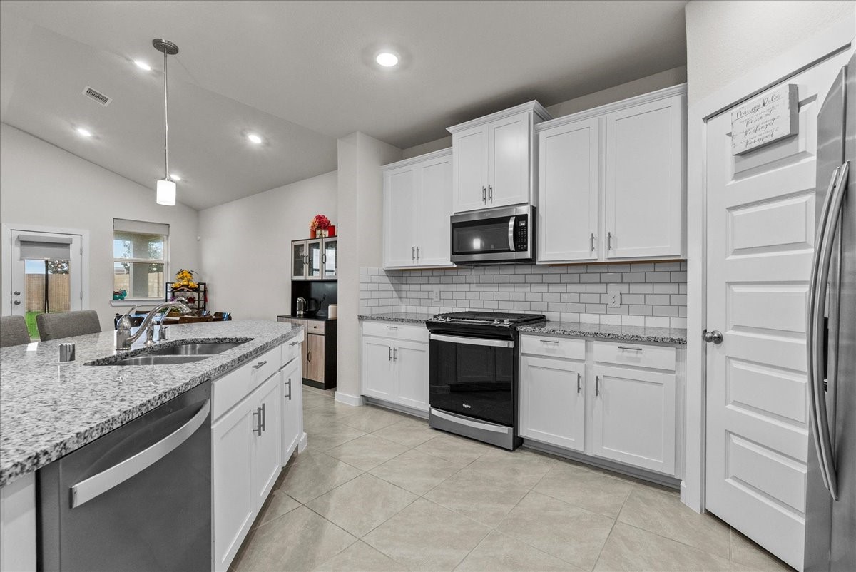 10831 Bodie Hls Drive Rosharon, TX 77583 - Photo 9 of 46 A clean, sleek kitchen design creates a calm and modern atmosphere. with white cabinetry, classic white subway backsplash and gorgeous granite countertops.