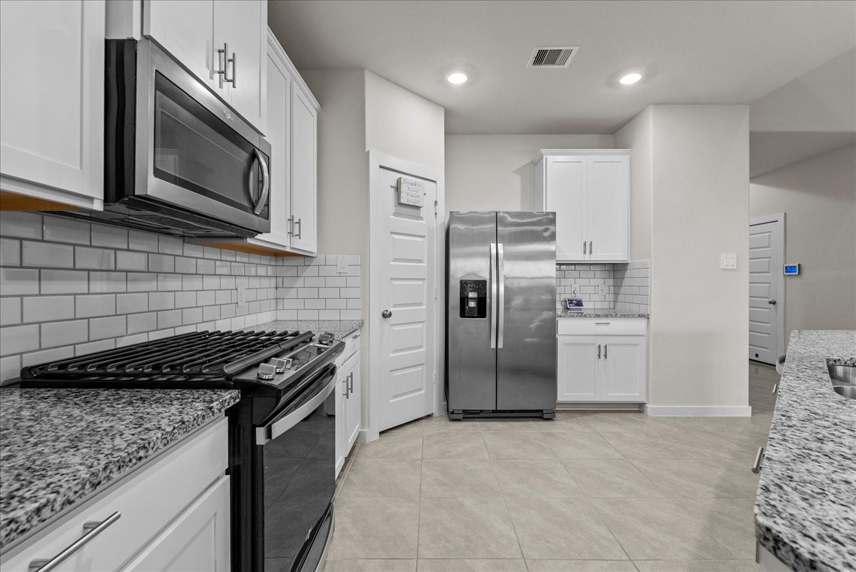 10831 Bodie Hls Drive Rosharon, TX 77583 - Photo 10 of 46 The stainless steel stove, oven, and microwave are thoughtfully aligned for efficiency, complemented by a spacious pantry.