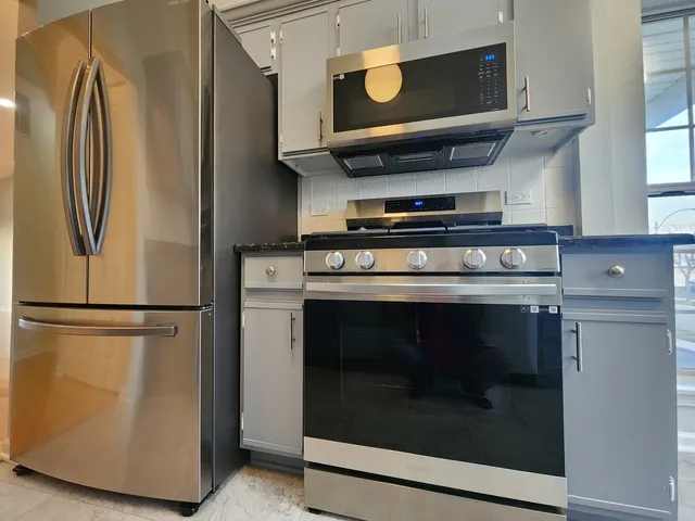 a kitchen with granite countertop a sink stove and cabinets