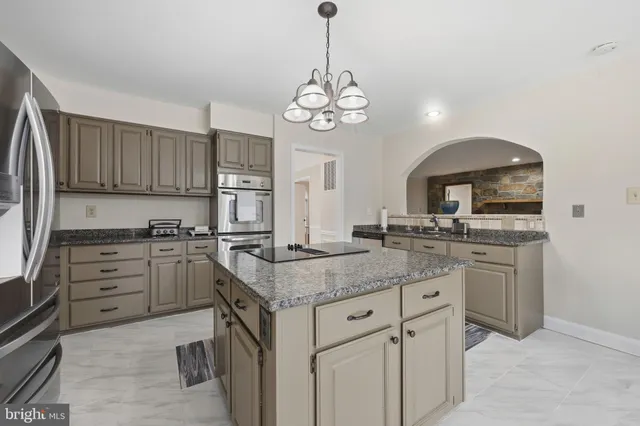 an empty room with chandelier fan and windows