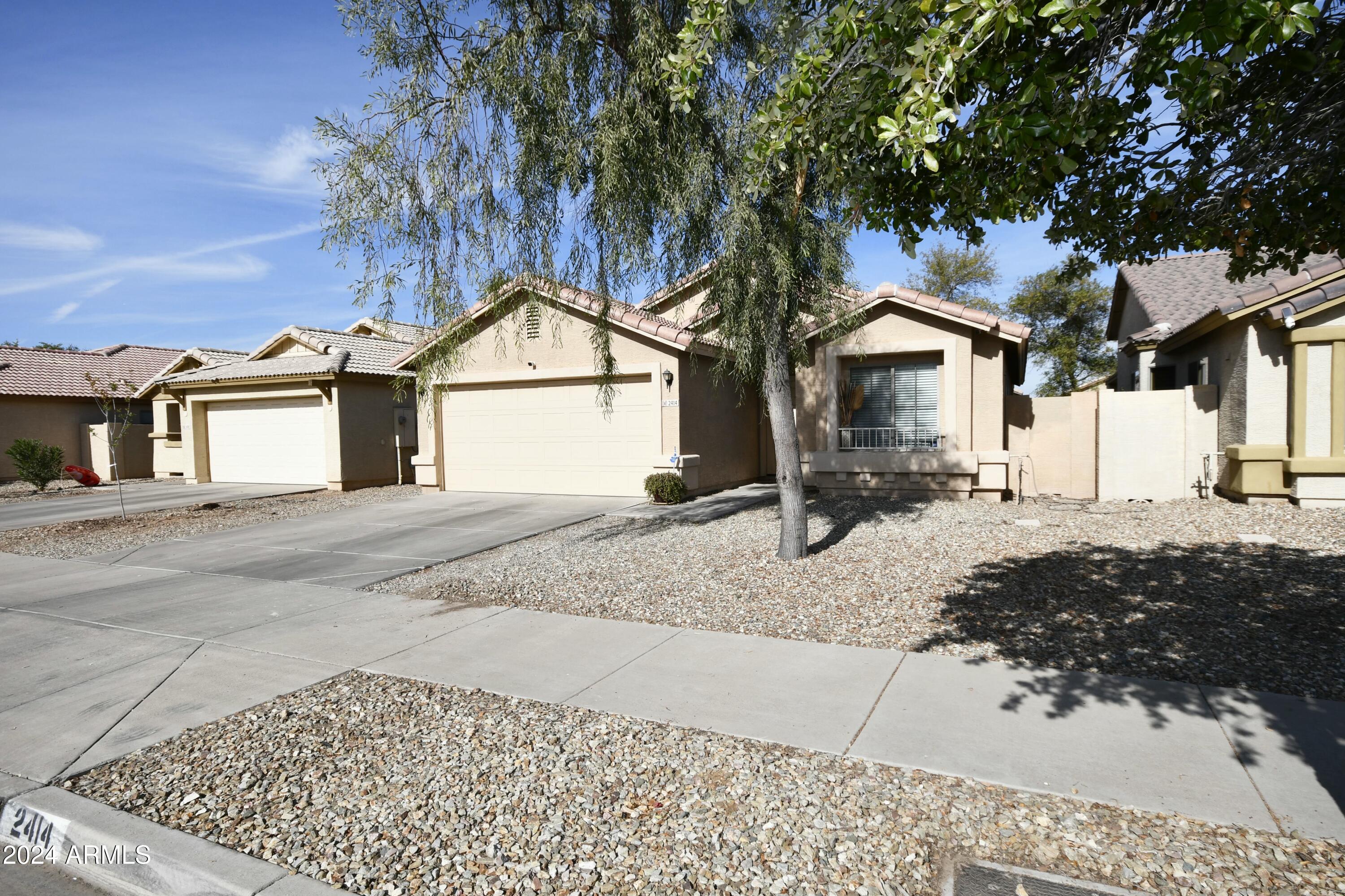 2414 West Gaby Road Phoenix, AZ 85041 - Photo 1 of 17 a tree in front of a white house