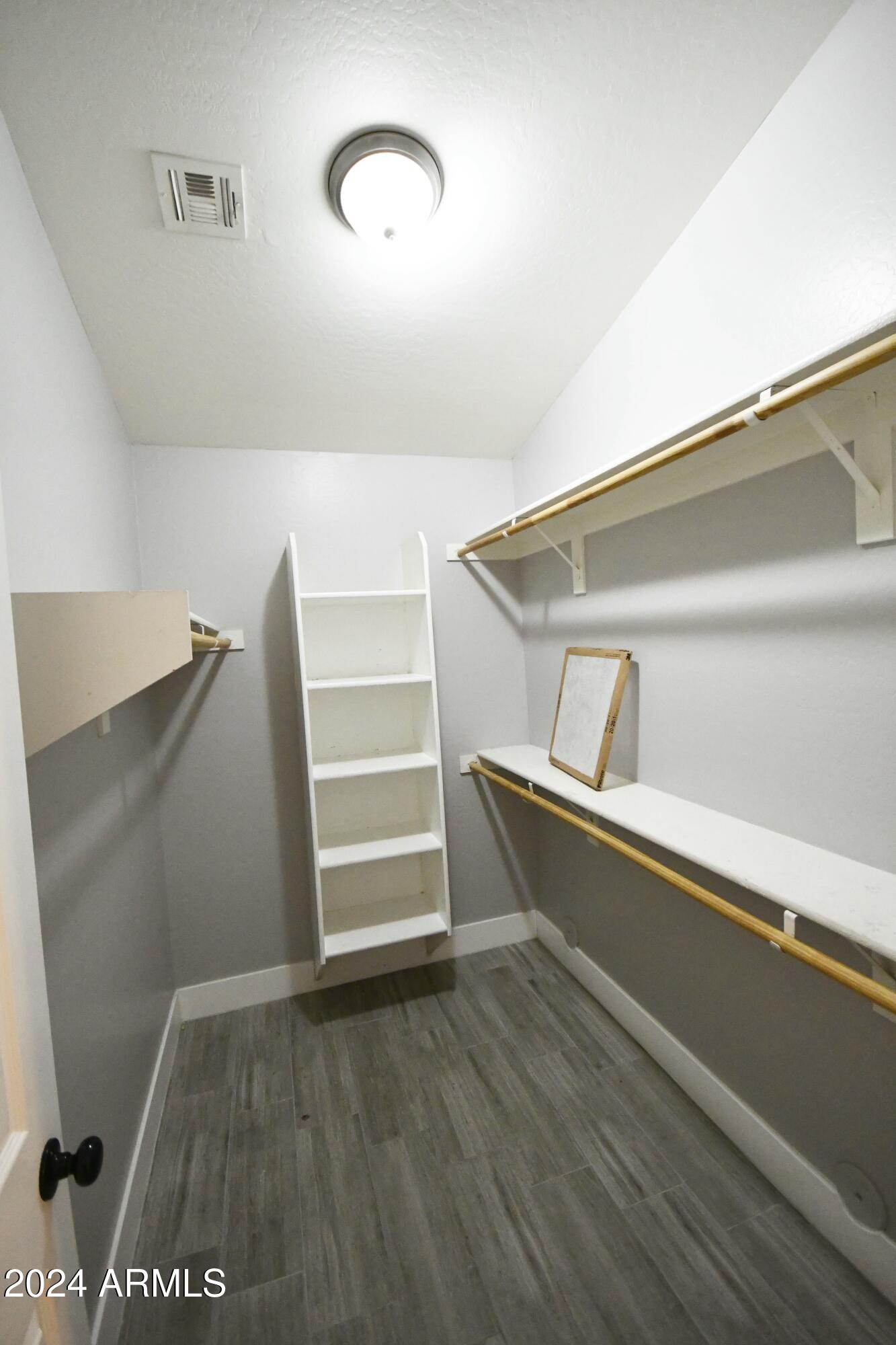 2414 West Gaby Road Phoenix, AZ 85041 - Photo 14 of 17 a view of walk in closet with empty racks