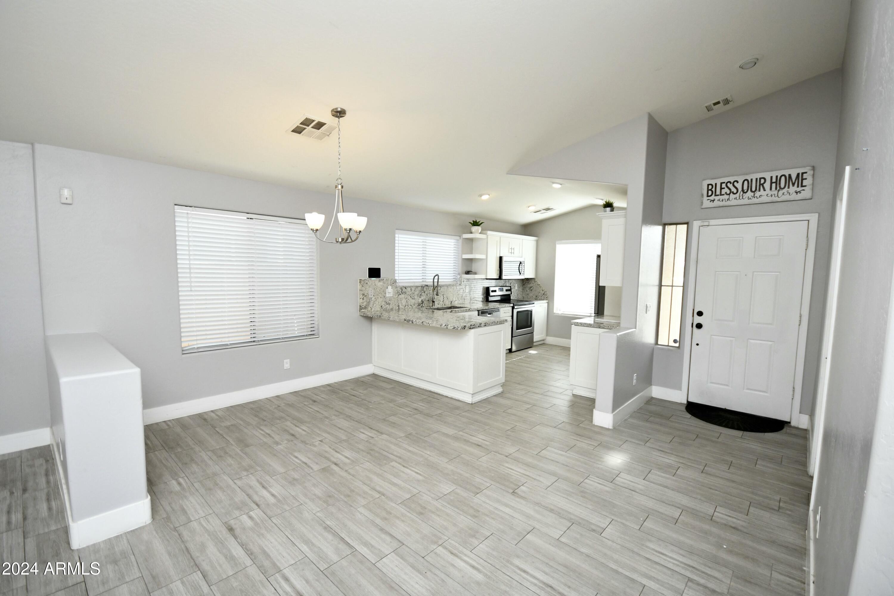 2414 West Gaby Road Phoenix, AZ 85041 - Photo 4 of 17 a large white kitchen with a white countertops a sink and a refrigerator