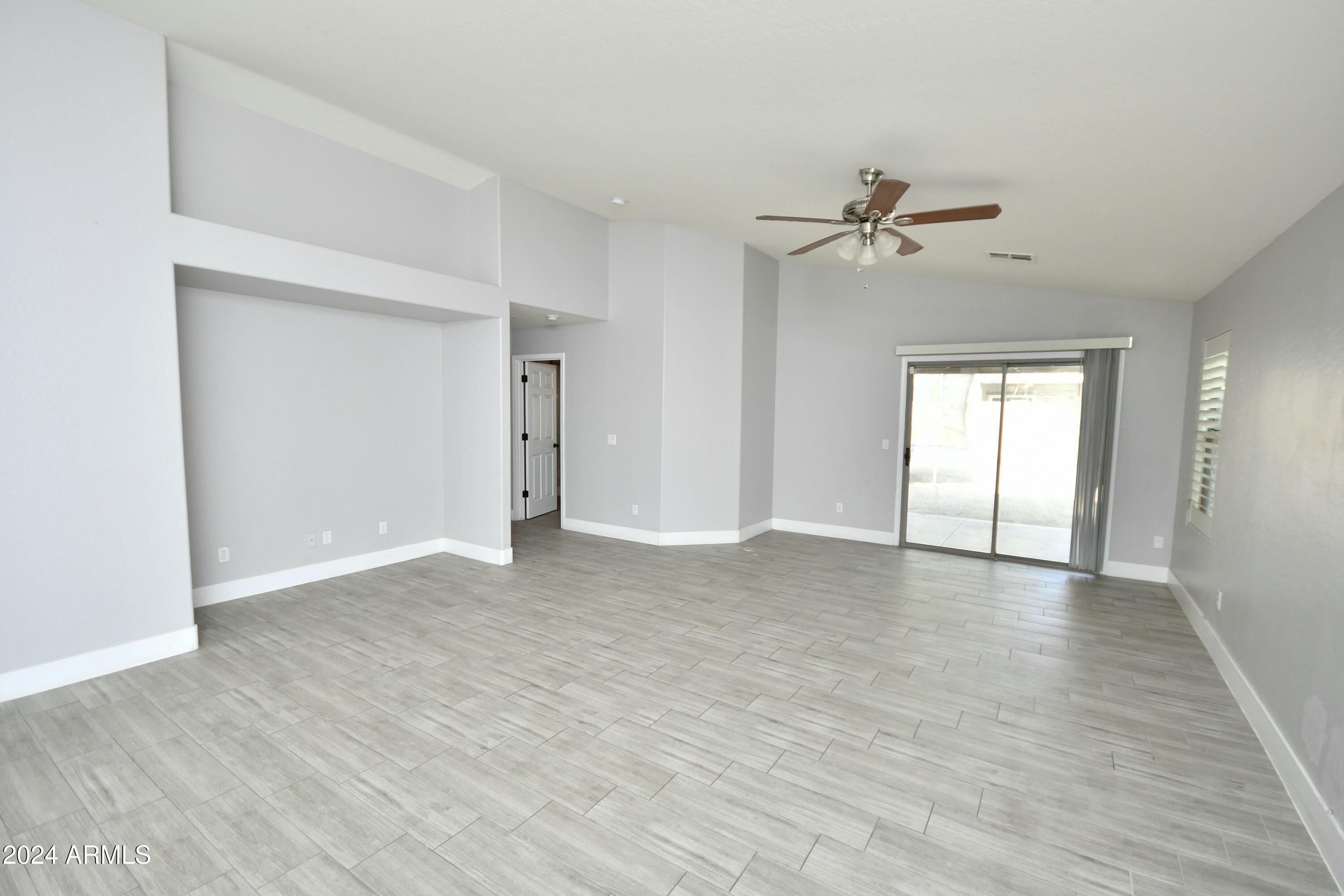 2414 West Gaby Road Phoenix, AZ 85041 - Photo 7 of 17 a view of a big room with wooden floor and windows in a room