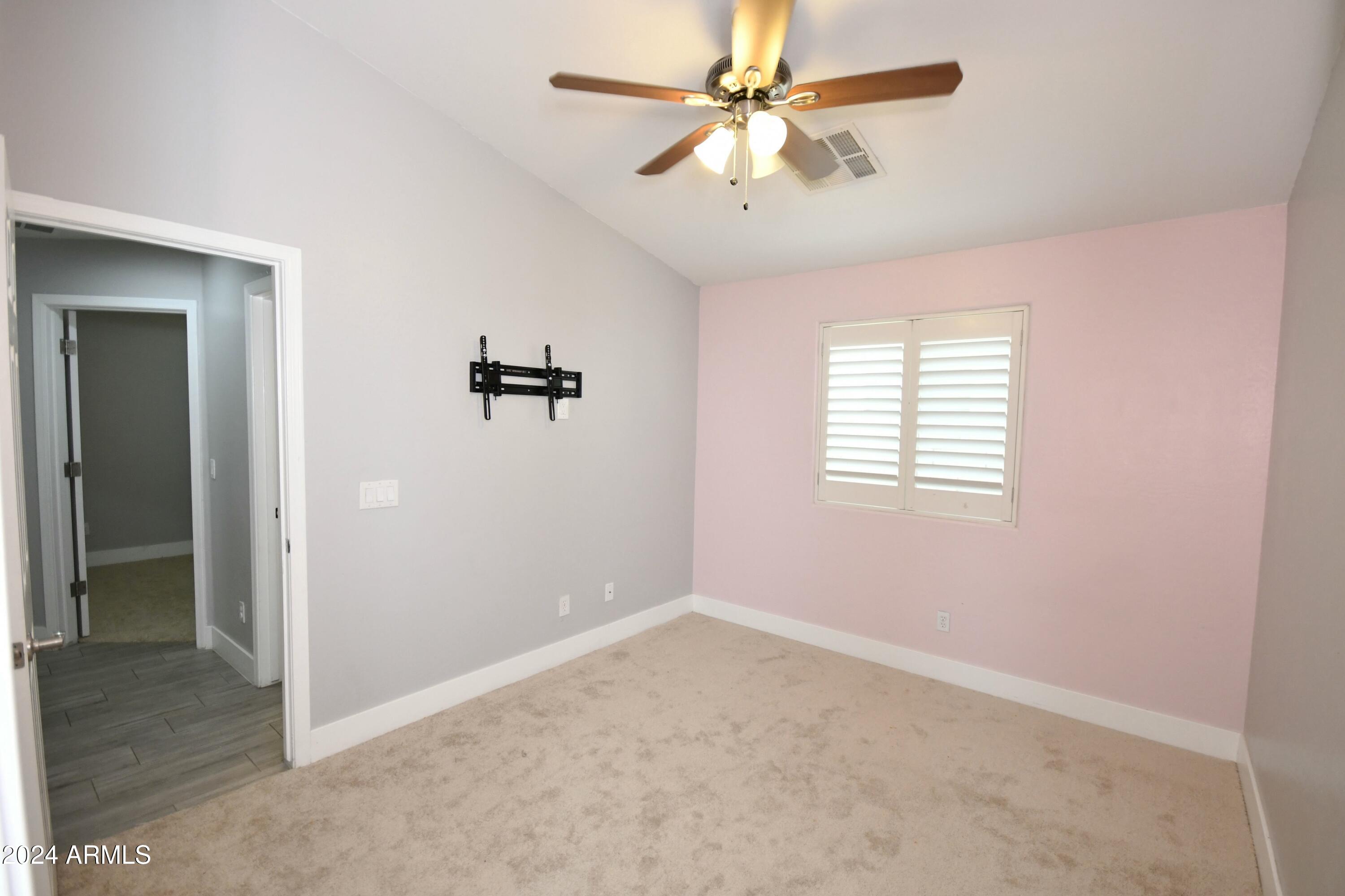 2414 West Gaby Road Phoenix, AZ 85041 - Photo 8 of 17 an empty room with windows and fan