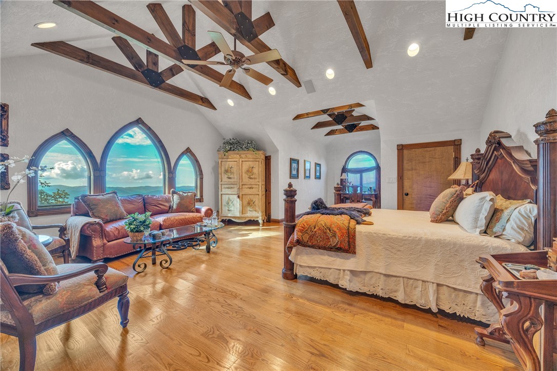 530 Howards Knob Road Boone, NC 28607 - Photo 21 of 49 a bedroom with a bed couch chandelier and a window