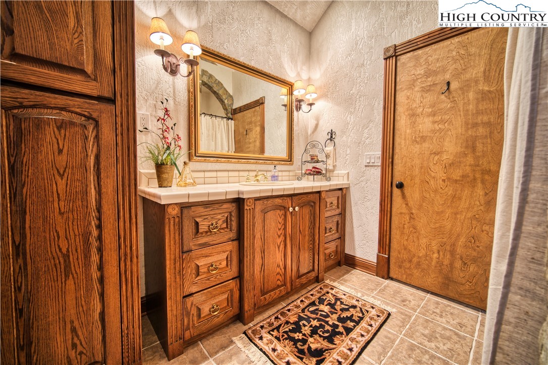 530 Howards Knob Road Boone, NC 28607 - Photo 26 of 49 a bathroom with a sink a mirror and a shower