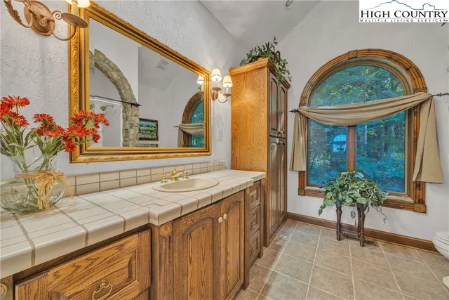 a en suite bathroom with a granite countertop sink and a mirror