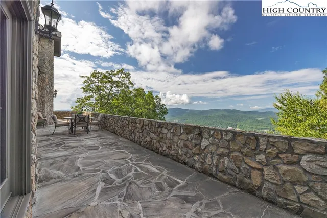 a view of a big house with plants and large trees