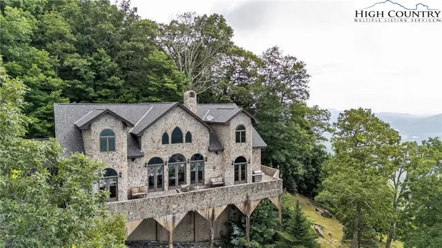 a view of a house with a yard and large trees