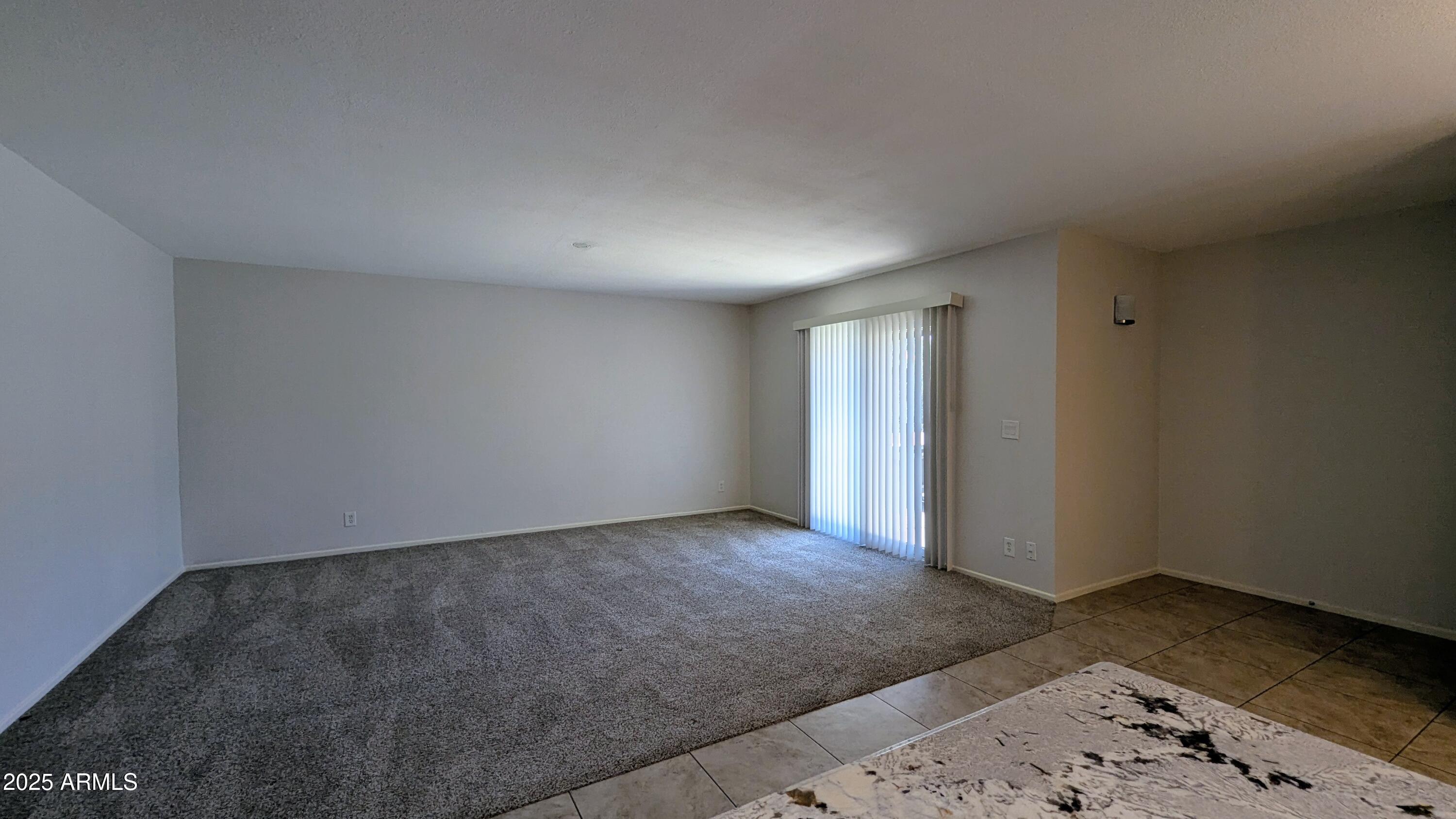 2228 East Campbell Avenue, Unit 234 Phoenix, AZ 85016 - Photo 11 of 18 an empty room with wooden floor and lamp
