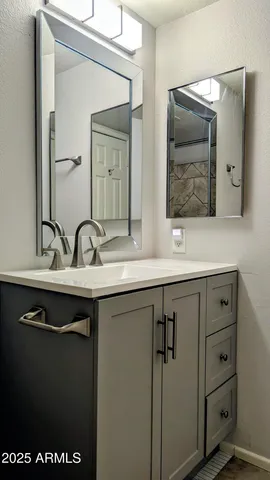 a bathroom with a sink and two mirror