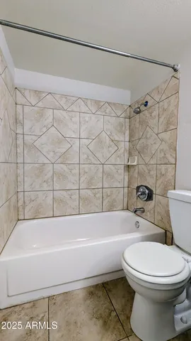 a bathroom with a toilet and a bath tub