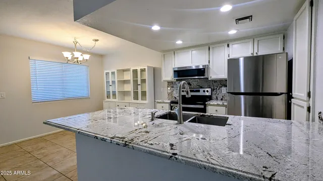 a kitchen with stainless steel appliances granite countertop a sink refrigerator and microwave