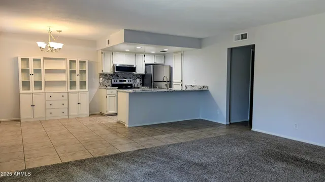 a kitchen with stainless steel appliances granite countertop a refrigerator and a stove top oven