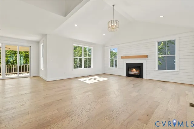 an empty room with windows and fireplace