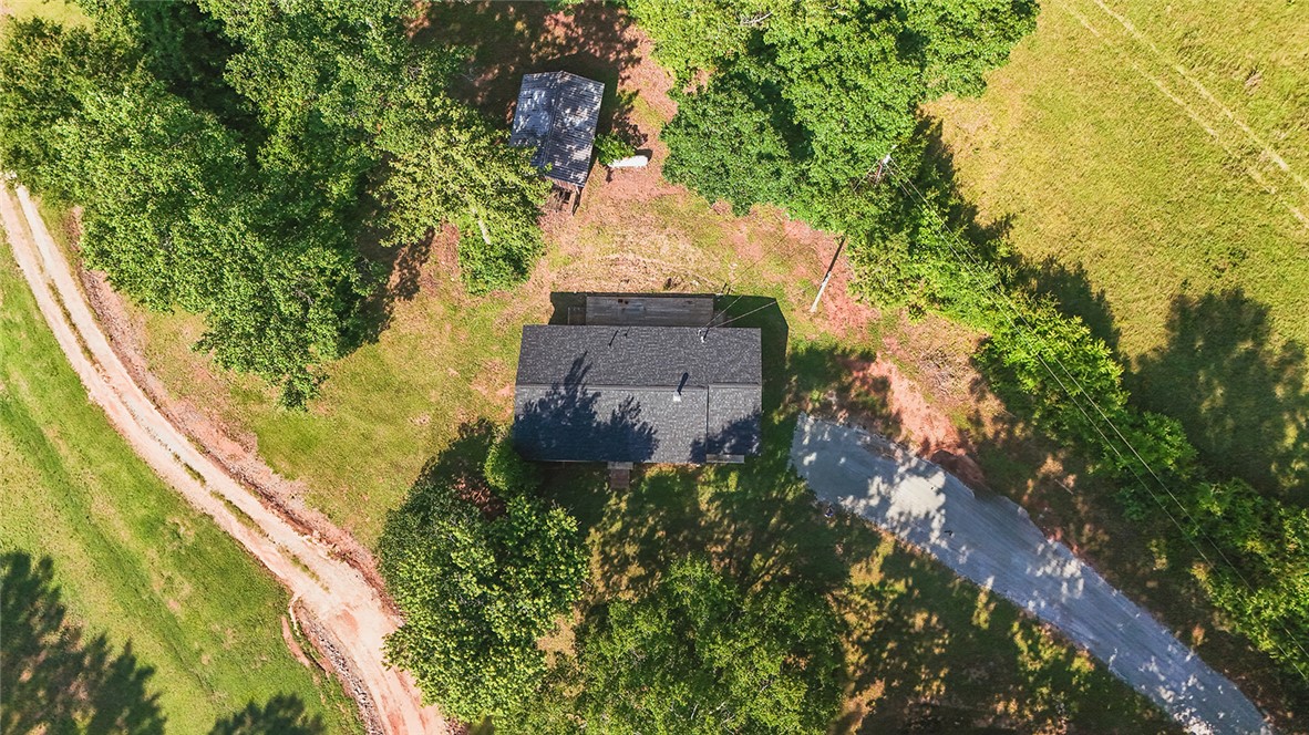 209 Cleveland Pike Road Westminster, SC 29693 - Photo 30 of 30 An aerial perspective reveals a cozy home nestled amongst lush greenery with access roads winding through the natural landscape.
