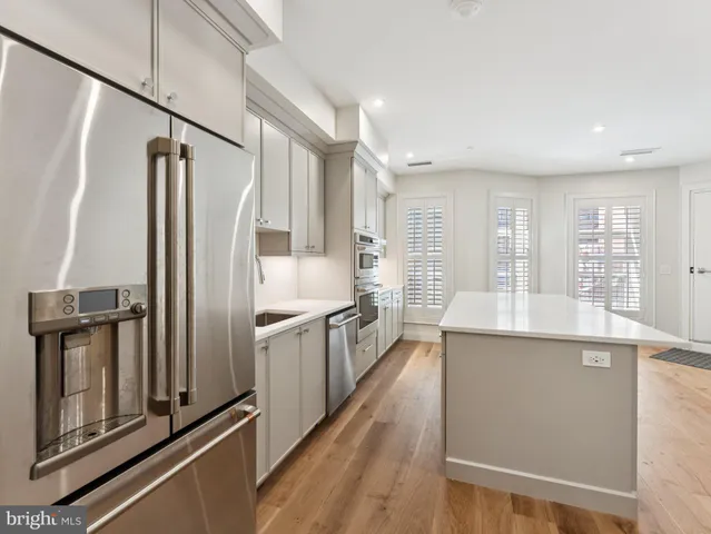 a kitchen with stainless steel appliances granite countertop a refrigerator a stove and a sink