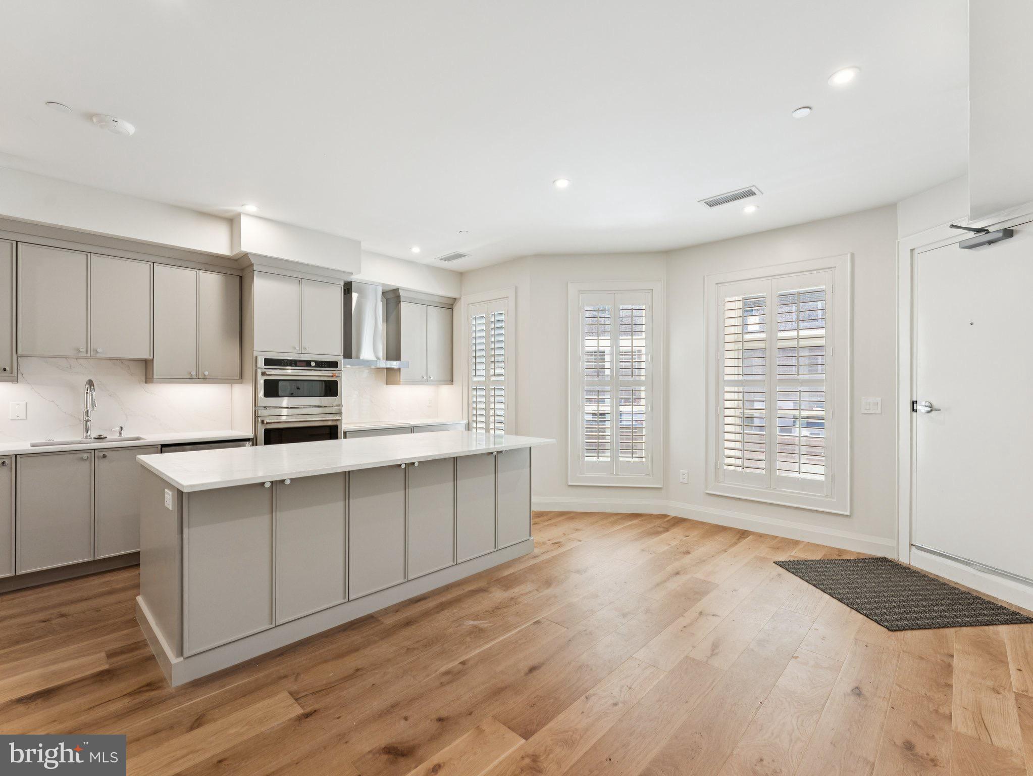 1508 21st Street Northwest, Unit 1 Washington, DC 20036 - Photo 18 of 40 a kitchen with stainless steel appliances a sink cabinets and wooden floor