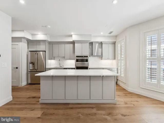 a kitchen with stainless steel appliances a refrigerator and a stove top oven
