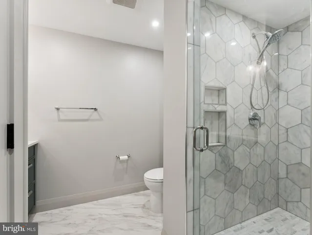 a bathroom with a granite countertop shower and a toilet