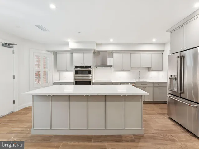 a kitchen with stainless steel appliances a stove a sink and a refrigerator