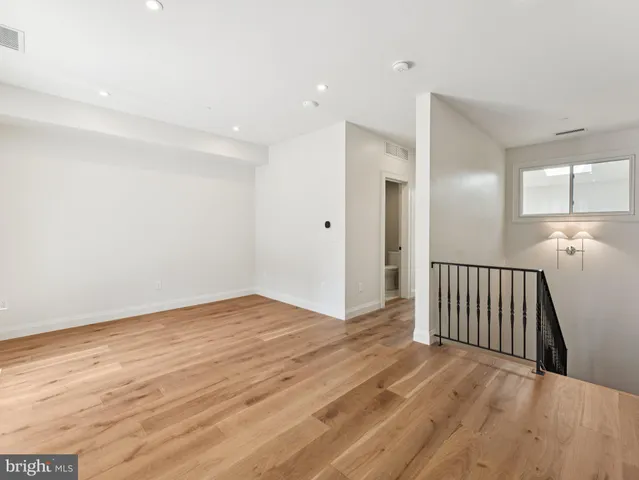 a view of an empty room with wooden floor