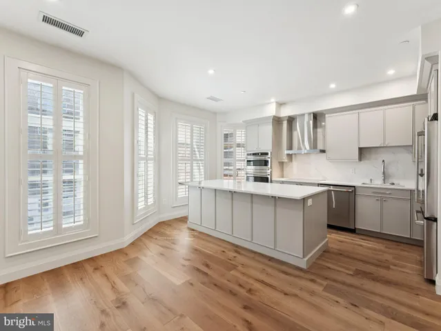 a kitchen with a white wooden cabinets and wooden floor