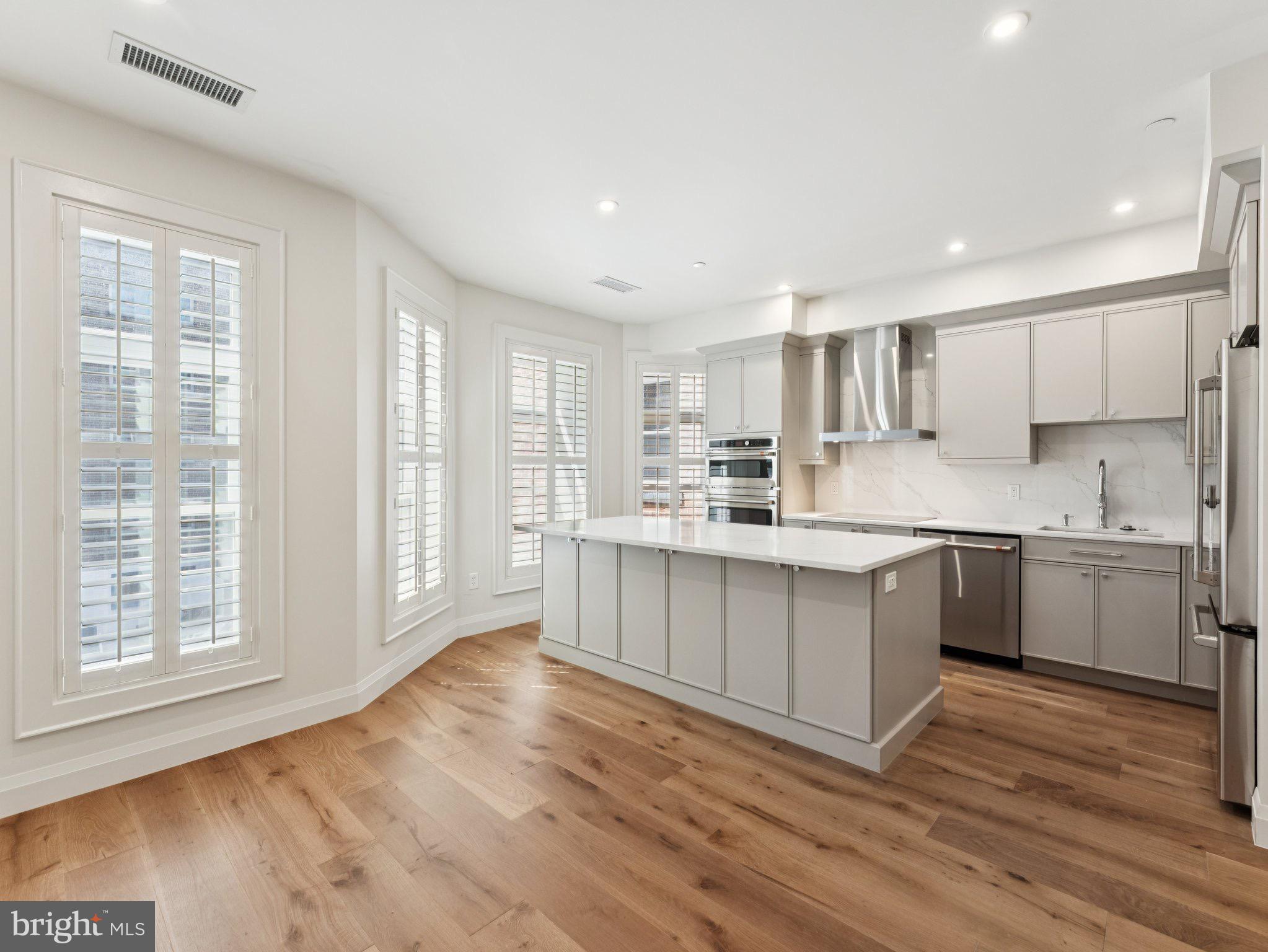 1508 21st Street Northwest, Unit 1 Washington, DC 20036 - Photo 10 of 40 a kitchen with a white wooden cabinets and wooden floor