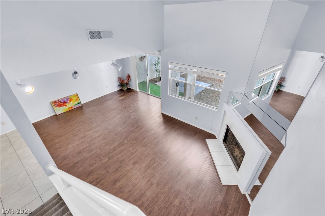 6250 West Flamingo Road, Unit 98 Las Vegas, NV 89103 - Photo 33 of 40 Living room featuring wood finished floors, a towering ceiling, a fireplace, and visible vents