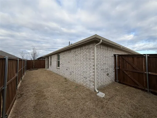 a backyard of a house with wooden fence