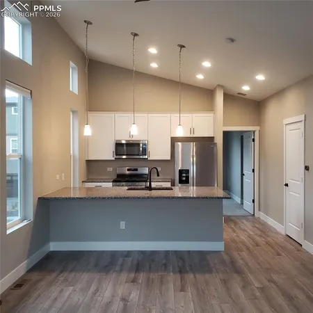 a kitchen with stainless steel appliances a refrigerator and a stove top oven