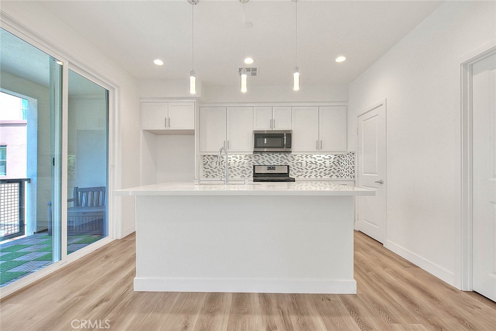 11411 VuePointe Way, Unit E El Monte, CA 91732 - Photo 11 of 38 a kitchen with stainless steel appliances a refrigerator sink and microwave