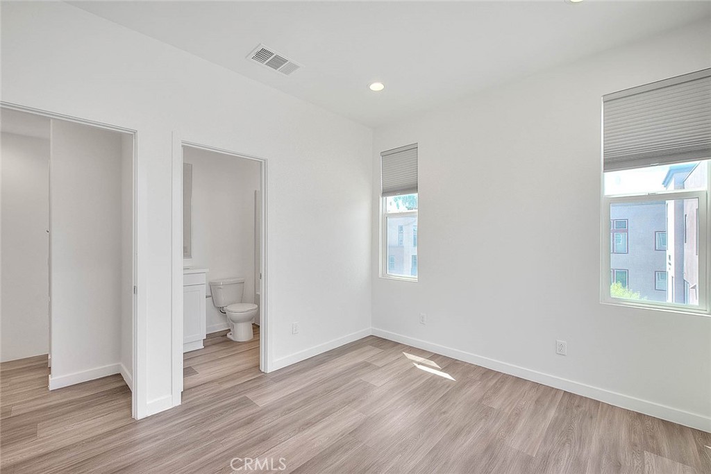 11411 VuePointe Way, Unit E El Monte, CA 91732 - Photo 30 of 38 an empty room with wooden floor and a window