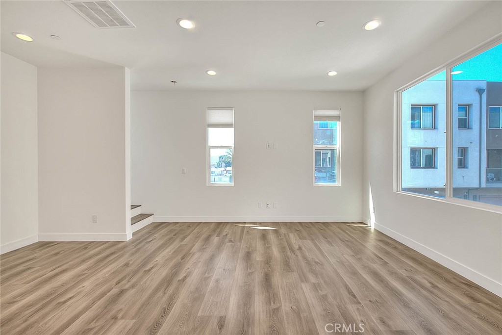 11411 VuePointe Way, Unit E El Monte, CA 91732 - Photo 6 of 38 an empty room with wooden floor and windows