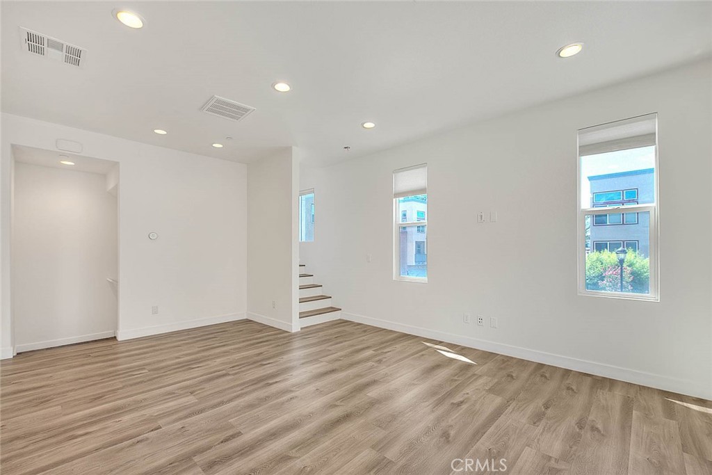 11411 VuePointe Way, Unit E El Monte, CA 91732 - Photo 7 of 38 an empty room with wooden floor and windows