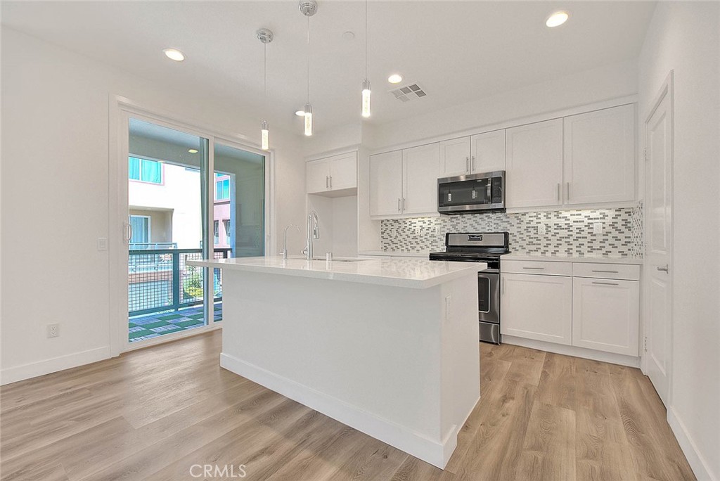 11411 VuePointe Way, Unit E El Monte, CA 91732 - Photo 10 of 38 a kitchen with stainless steel appliances a refrigerator sink and microwave