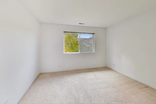 front view of a house with a large tree