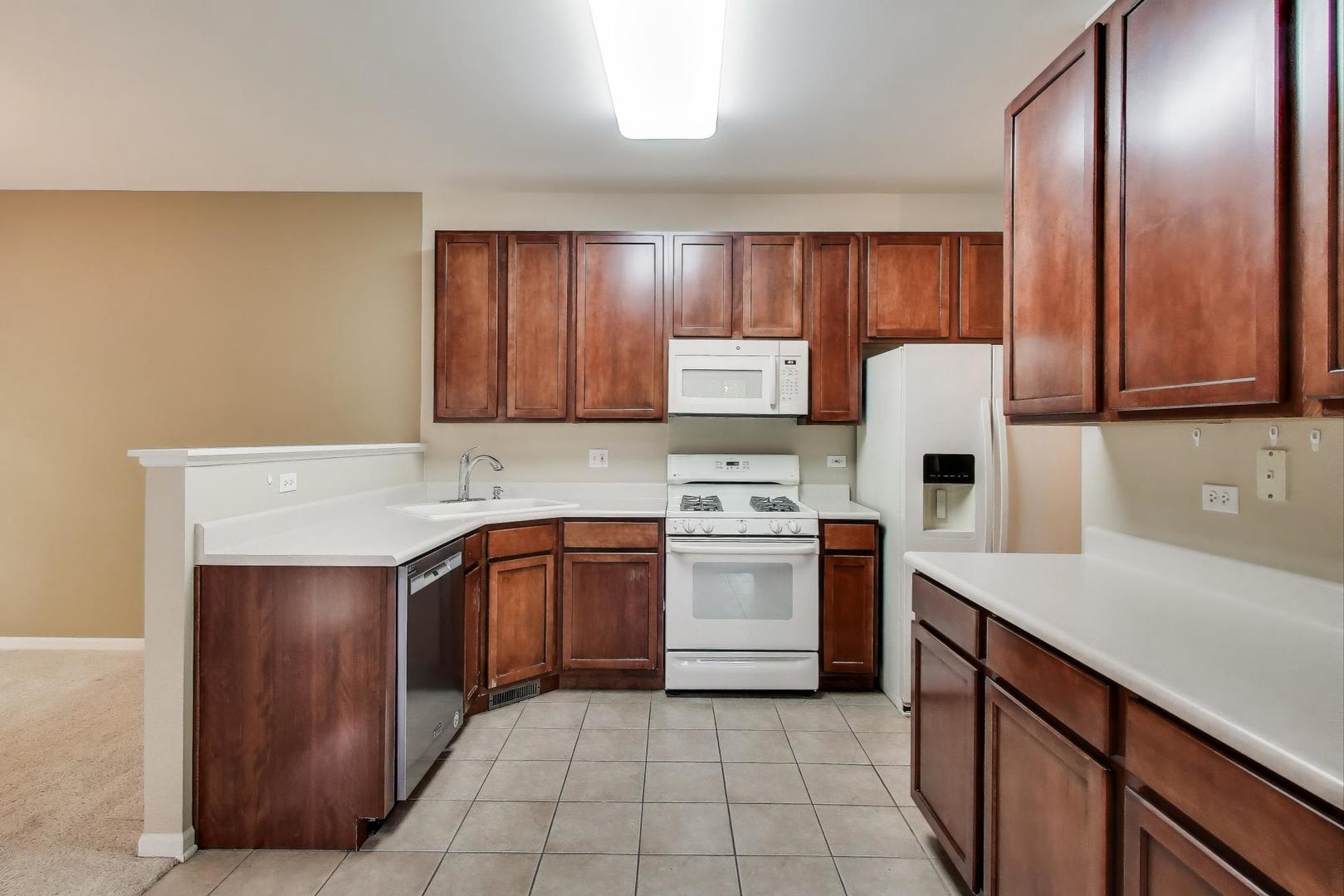 2271 Stoughton Circle Aurora, IL 60502 - Photo 6 of 34 a kitchen with stainless steel appliances granite countertop a sink stove refrigerator and cabinets