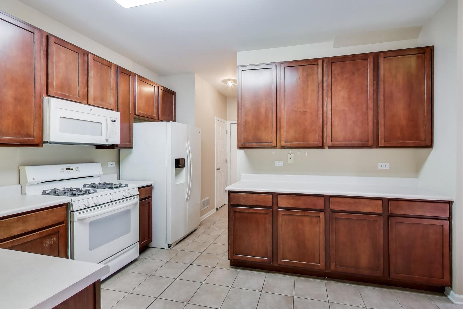 2271 Stoughton Circle Aurora, IL 60502 - Photo 7 of 34 a kitchen with stainless steel appliances granite countertop wooden cabinets a sink and a stove