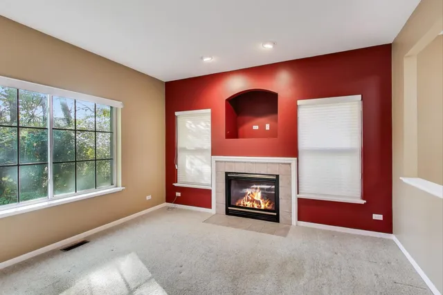 a view of an empty room with a fireplace and a window