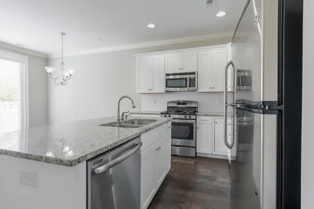 a kitchen with stainless steel appliances granite countertop a sink stove and refrigerator