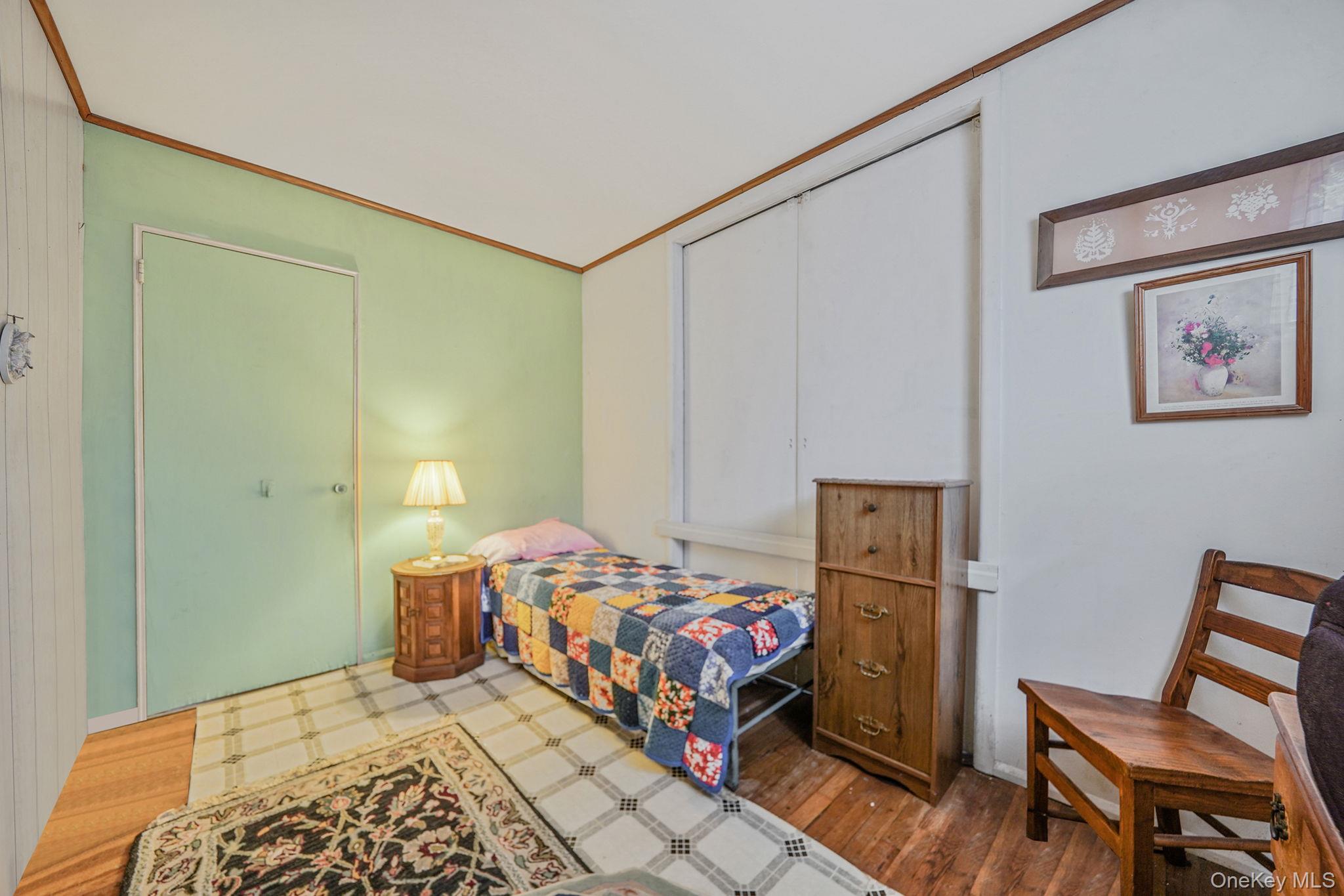 2 Sydney Street Plainview, NY 11803 - Photo 18 of 26 a bedroom with a bed and wooden floor